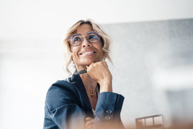 Smiling businesswoman with hand on chin at office model released, Symbolfoto property released, JOSEF14102