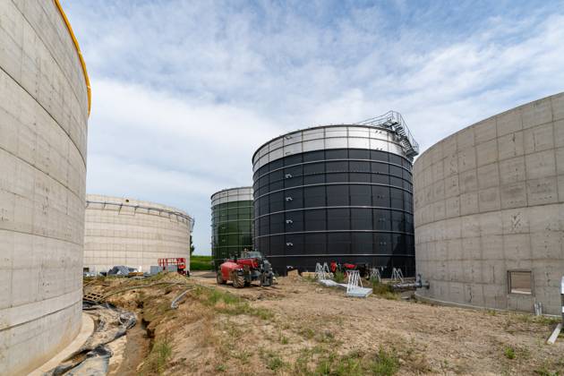 Neubau einer großen Biogasanlage - Steiger inmitten riesiger Betonhochbehälter, Symbolfoto. Neubau einer Biogasanlage und einer Biogasaufbereitungsanlage der Firma NDEnergie in Bohmte OT Stirpe-Oelingen direkt am Hafen des Mittellandkanals. Dazu gehört eine Anlage zur Stromerzeugung für mehrere tausend Haushalte, entweder durch Biogas oder Erdgas. Ausgangsstoffe sind vorwiegend tierische Abfälle wie Hähnchen- und Putenmist sowie Gülle aus der Rinder- und Schweinehaltung. Ferner ist eine CO2 - Abscheidung und -Lagerung vorgesehen. Bohmte Niedersachsen Deutschland