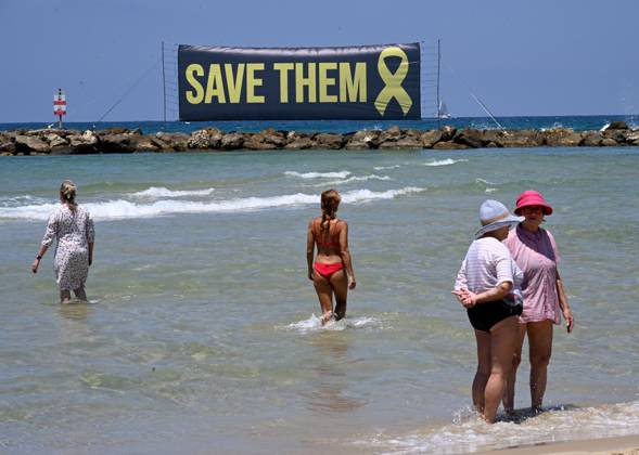 Bilder des Jahres 2025, News 07 Juli News Themen der Woche KW27 A banner calling for the release of Israeli hostages still held by Hamas in Gaza since October 7, 2023, is displayed in the Mediterranean Sea in front of the U.S. Embassy branch in Tel Aviv on Friday, July 4, 2025. Released hostages joined families whose loved ones are held in Hamas captivity in a protest calling on U.S. President Donald Trump to bring all the hostages home and end the war.  JER2025070402 DEBBIExHILL