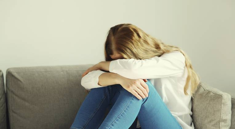 Aufgewühlte, traurige, weinende Frau, die ihre Augen und ihr Gesicht mit den Händen bedeckt, während sie unter Depressionen, Stress, Müdigkeit und seelischem Leid leidet und zu Hause auf der Couch sitzt Upset sad crying woman covering her eyes and face with her hands while experiencing depression, stress, fatigue, mental suffering sitting on the couch at home Copyright: imageBROKER VeronikaxKorneva ibxiqx14273009.jpg ,model released, Symbolfoto ,property released