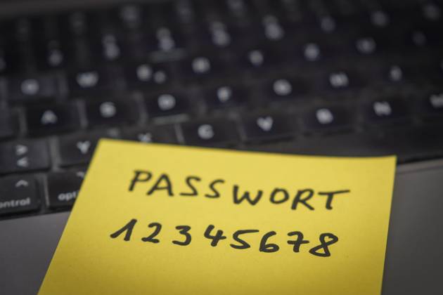 Sicherheitsrisiko auf dem Schreibtisch: Ein Zettel mit dem unsicheren Passwort 12345678 liegt offen auf einem Laptop, ein klassisches Beispiel für fahrlässigen Umgang mit sensiblen Zugangsdaten.