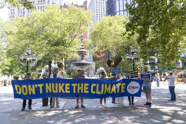 July 16, 2025, New York, New York, USA: Members of New York Campaign To Abolish Nuclear Weapons (NYCAN) hold sunflowers and a banner and signs that read DON T NUKE THE CLIMATE NUCLEAR DISARMAMENT NOW! NUCLEAR WEAPONS KILL EVERYTHING FIRST WE BOMBED NEW MEXICO at a vigil in City Hall Park marking 80 years since the U.S. government s Trinity Test, the detonation of the first nuclear weapon on July 16, 1945 in the Tularosa Basin in New Mexico. The protest is held across the street from the original Manhattan Project offices at 270 Broadway in lower Manhattan. Demonstrators call for worldwide nuclear abolition and mourn for the illness and harm to people and lands from radioactive contamination caused by nuclear tests and atomic bombs. - ZUMAr174 20250716_znp_r174_015 Copyright: xGinaxMxRandazzox