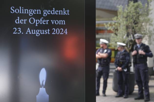 Ein Jahr nach dem terroristischen Anschlag in Solingen wird am Samstag (23.08.2025) der Opfer gedacht (Foto: Polizisten stehen neben einer digitalen Gedenktafel). Bei dem islamistisch motivierten Messeranschlag am 23. August 2024 hatte ein als Asylbewerber nach Deutschland gekommener Syrer Besucher des Solinger Stadtfestes zum 650-jaehrigen Bestehen angegriffen. Drei Menschen wurden durch Stiche getoetet und acht verletzt. Gegen den mutmasslichen Taeter Issa al H. laeuft derzeit der Prozess vor dem Oberlandesgericht Duesseldorf. Der Anschlag hatte eine intensive Debatte ueber die Asyl- und Fluechtlingspolitik ausgeloest. (Siehe epd-Meldungen vom 23.08.2025) EDITORIAL USE ONLY