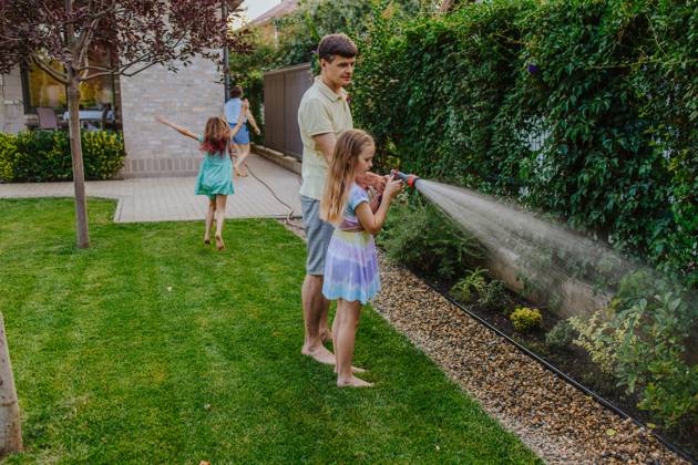 Family gardening together outdoors and watering plants in summer model released, Symbolfoto property released, MDOF02998
