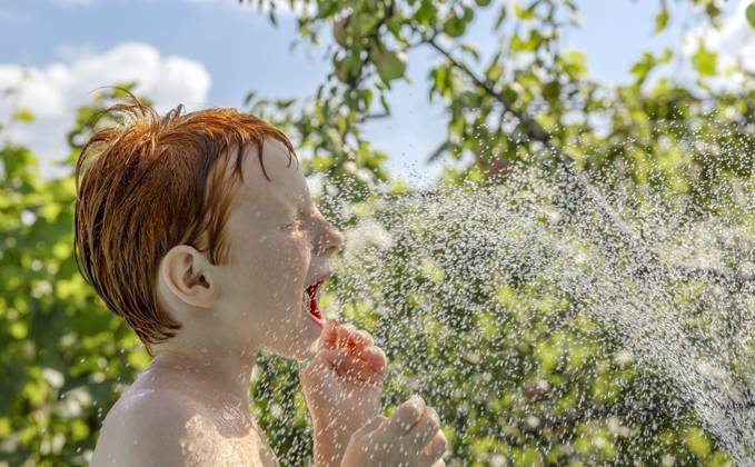 Red-haired child playing and splashing in outdoor pool on a sunny day model released, Symbolfoto, MBLF01008