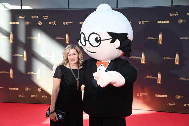 Gesine CUKROWSKI, Schauspielerin, mit Mainzelmaennchen Det, Roter Teppich, Red Carpet Show, Ankunft, arrival, Verleihung des Deutschen Fernsehpreises, Der Deutsche Fernsehpreis 2025, Deutscher Fernsehpreis 2025 in den MMC Studios Koeln, am 10.09.2025.