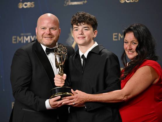 British actor Owen Cooper (C) holds the Emmy for Outstanding Supporting Actor in a Limited or Anthology Series or Movie for Adolescence, alongside his parents Noreen (R) and Andy Cooper (L) backstage during the 77th annual Primetime Emmy Awards at the Peacock Theater in Los Angeles on Sunday, September 14, 2025.  LAP20250914194 CHISxCHEW