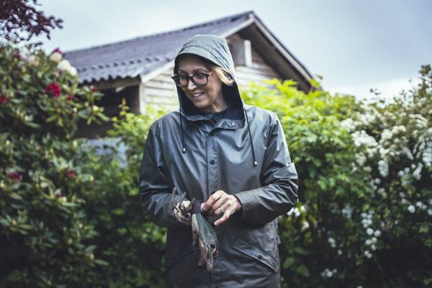 IMAGO Creative, Jahreszeit Sommer, Regen, Sommerregen Woman With Gardening Gloves Surrounded By Lush Nature Haarby, Denmark CR_EMWIXA250917-1832601-01 ,model released, Symbolfoto