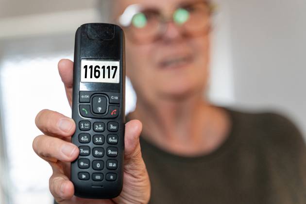 FOTOMONTAGE, Eine Frau hält ein Telefon mit der Nummer 116117 im Display. Symbolbild für den ärztlichen Bereitschaftsdienst in Deutschland. Kontaktstelle für Patienten, die außerhalb der Praxiszeiten Hilfe benötigen