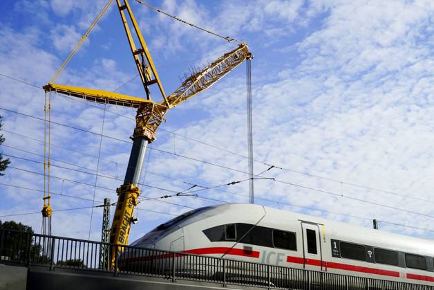 CNTV-BAHNSANIERUNG-Brueckenarbeiten Arbeiter der DB Bahn arbeiten mit Schutzkleidung bei laufenden Bahnverkehr ICE mit Bagger Krahn an neuen Gleisen , verlegen Brueckenteile Schienen und Betonschwellen.Die Bauarbeiten an der Strecke zwischen Hamburg und Berlin laufen planmaessig - Hamburg Oktober 2025 Hamburg Deutschland