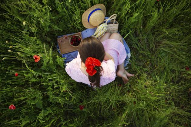 Eine junge Frau genießt ein ruhiges Picknick inmitten eines lebendigen Mohnfeldes, umgeben von der Schönheit der Natur A young woman enjoys a tranquil picnic amidst a vibrant poppy field, surrounded by nature s beauty Copyright: imageBROKER SergiyxArtsaba ibxiqx14689866.jpg ,model released, Symbolfoto ,property released