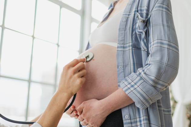 Arzt untersucht schwangere Frau hält Stethoskop in der Nähe von großen Bauch hören Baby Herzschlag. Gynäkologe Arzt Beratung Patientin über Schwangerschaft im Krankenhaus Büro. Besuch beim Arzt medizinischen Checkup. Doctor examining pregnant woman holding stethoscope near big belly listening baby heartbeat. Gynecologist doctor consulting patient about pregnancy in hospital office. Visit to doctor medical checkup (License=RF) ,model released, Symbolfoto Copyright: xZoonar.com IuliiaxZavalishinax 24095594 ,model released, Symbolfoto ,property released