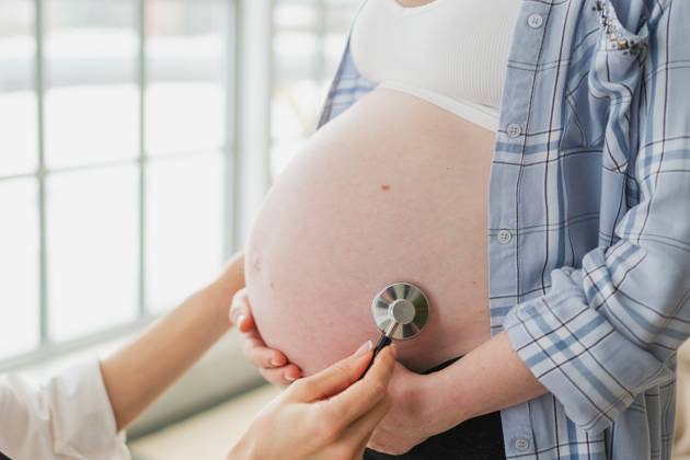 Arzt untersucht schwangere Frau hält Stethoskop in der Nähe von großen Bauch hören Baby Herzschlag. Gynäkologe Arzt Beratung Patientin über Schwangerschaft im Krankenhaus Büro. Besuch beim Arzt medizinischen Checkup. Doctor examining pregnant woman holding stethoscope near big belly listening baby heartbeat. Gynecologist doctor consulting patient about pregnancy in hospital office. Visit to doctor medical checkup (License=RF) ,model released, Symbolfoto Copyright: xZoonar.com IuliiaxZavalishinax 24095620 ,model released, Symbolfoto ,property released