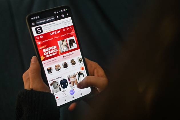 November 11, 2025, Clermont-Ferrand, Auvergne Rhone Alpes, France: A woman scrolls on a phone on Shein online store in Clermont-Ferrand, France, on November 11, 2025. The government still wants to get the Chinese platform suspended in France, where it is facing several legal proceedings. A procedure to suspend the Chinese giant has been initiated in France, a decision taken after the scandal involving child pornography sex dolls. Clermont-Ferrand France - ZUMAf173 20251111_zip_f173_004 Copyright: xAdrienxFillonx