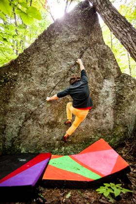 A rock climber climbs the face of a boulder with crash pads below United States, New Hampshire, Keene CR_VAWG251110-1874753-01 ,model released, Symbolfoto
