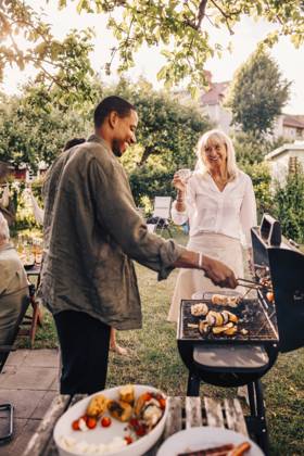 IMAGO Creative, Lifestyle, Feste im Garten #2 Happy man barbecuing while talking with mother in back yard at dinner party Sweden, Stockholm, model released Copyright: xMaskotx , MA120724 MA120724