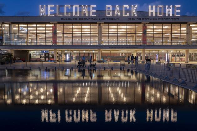 Israeli civilians seen before the Charles Bronfman Auditorium, which is next to the Mann Auditorium, in HaBima Square in Tel Aviv, Israel, as the Welcome Back Home large sign lights up at sundown on Saturday, November 15, 2025. Israel awaits the last 3 dead bodies that the Hamas should return to fulfill the first phase of the US-backed peace plan between Israel and the Hamas forces. Phase 2, when it begins, will be crucial as Hamas is supposed to disarm.  ISR20251115001 JimxHollander