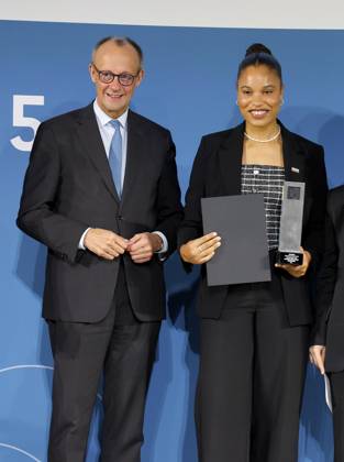 Schirmherr Bundeskanzler Friedrich Merz, Yemisi Semechin (Kugelstoßerin). bei der Verleihung des TALISMAN 2025 der Deutschlandstiftung Integration im Allianz Forum in Berlin.