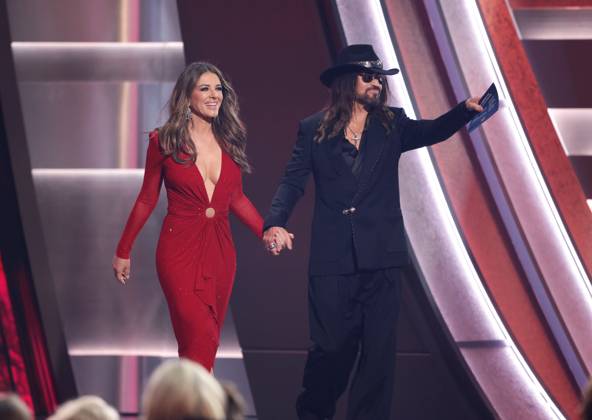 (L-R) Elizabeth Hurley and Billy Ray Cyrus appear onstage during the 59th CMA Awards at the Bridgestone Arena in Nashville, Tennessee, on Wednesday, November 19, 2025.  NAS20251119281 JOHNxANGELILLO