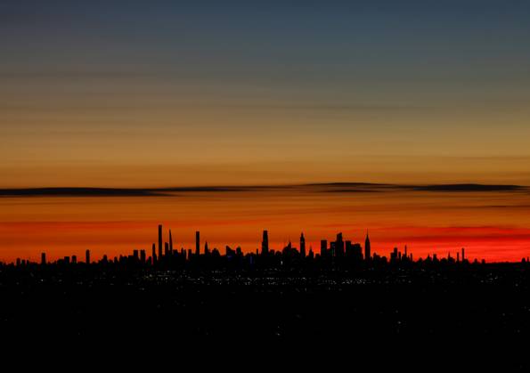 Clouds turn shades of red and orange before sunrise behind The Empire State Building and the Manhattan skyline on Sunday, November 23, 2025 in West Orange, New Jersey.  NYP20251123102 JOHNxANGELILLO