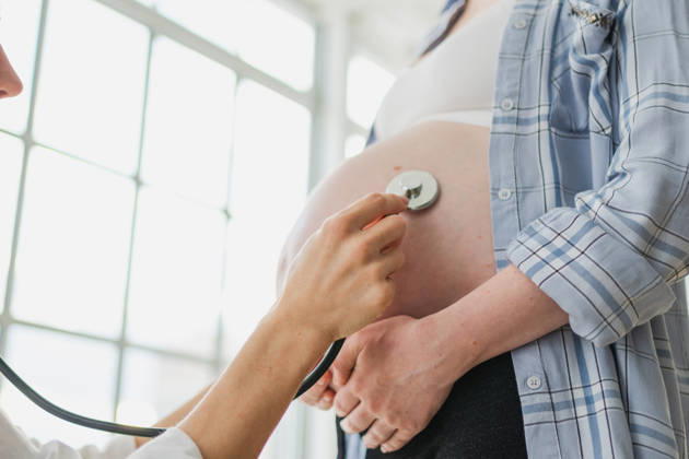 Arzt untersucht schwangere Frau hält Stethoskop in der Nähe von großen Bauch hören Baby Herzschlag. Gynäkologe Arzt Beratung Patientin über Schwangerschaft im Krankenhaus Büro. Besuch beim Arzt medizinischen Checkup. Doctor examining pregnant woman holding stethoscope near big belly listening baby heartbeat. Gynecologist doctor consulting patient about pregnancy in hospital office. Visit to doctor medical checkup (License=RF) ,model released, Symbolfoto Copyright: xZoonar.com IuliiaxZavalishinax 24281026 ,model released, Symbolfoto ,property released