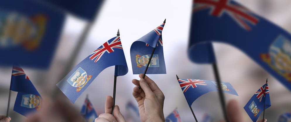 Flaggen der Falklandinseln in ihren Händen vor einem unscharfen städtischen Hintergrund Falkland Islands flags in their hands on a blurred urban background. The photo illustration was created without the use of artificial intelligence, only using Photoshop. (License=RF) Copyright: xZoonar.com AlekseyxButenkovx 24303803