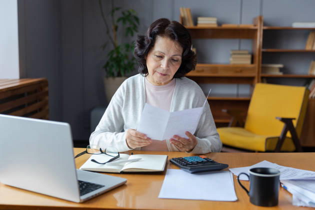 Middle aged senior Frau sitzen mit Laptop und Papier Dokument, Pensive ältere reife Dame Lesen Papier Rechnung zahlen online zu Hause verwalten Bank Finanzen Berechnung Steuern Planung Darlehen Schulden Rente Zahlung Middle aged senior woman sit with laptop and paper document. Pensive older mature lady reading paper bill pay online at home managing bank finances calculating taxes planning loan debt pension payment (License=RF) ,model released, Symbolfoto Copyright: xZoonar.com IuliiaxZavalishinax 24349953 ,model released, Symbolfoto ,property released