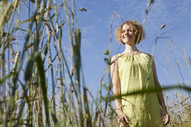 Smiling person in summer dress standing in tall grass outdoors in Munich model released, Symbolfoto, LDF000853