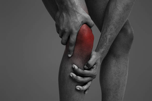 Young man massaging his painful knee, close up Trauma, stretching. Cropped of black man massaging his sore injured knee, white background, model released, , 62283580.jpg RECORD DATE NOT STATED