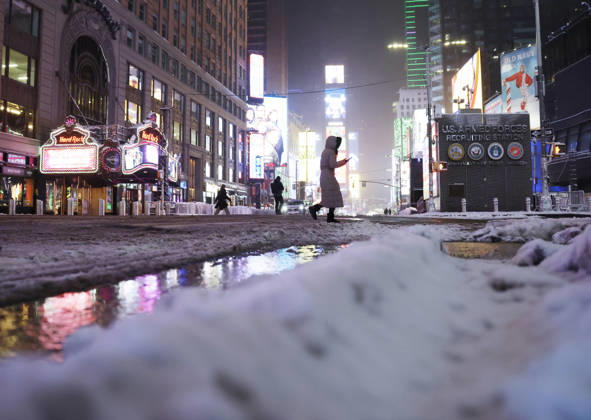 Pedestrians cross Seventh Avenue near Times Square as snow falls in the early morning on Saturday, December 27, 2025 in New York City. A winter storm warning was issued for the entire metro area, from southern Connecticut to northeast New Jersey and southeast New York.  NYP20251227104 JOHNxANGELILLO