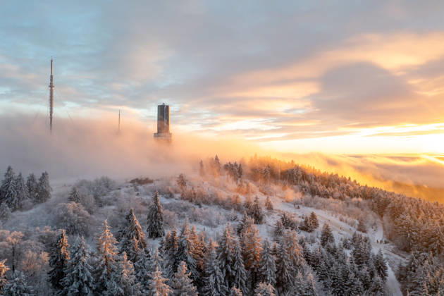 Winterabend im Taunus Der Gipfel des Großen Feldbergs im Taunus ragt bei Sonnenuntergang aus dem Hochnebel., Schmitten Hessen Deutschland