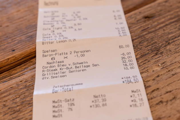Kassenbon zeigt Mehrwertsteuer von 7 und 19 Prozent in der Gastronomie 13.01.26, Selters: Symbolfoto, Illustrationsbild, Symbolbild, Illustrationsfoto, Alltagsszene Detailaufnahme eines Kassenbons auf einem Holztisch. Auf dem Beleg sind unterschiedliche Mehrwertsteuersätze ausgewiesen, darunter 7 Prozent und 19 Prozent. Das Bild thematisiert die Mehrwertsteuerregelung in der Gastronomie sowie steuerliche Abgaben auf Speisen und Getränke. Selters Hessen Deutschland Copyright: xThorstenxWagnerx