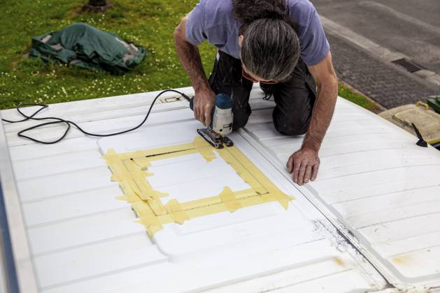 Umbau eines Camper Jumper Van zum Selbermachen. Neues Fenster draußen Schneiden mit einer elektrischen Stichsäge. Vorbereitung für die Installation eines Dachfensters DIY Camper Jumper van conversion. new window outside. cutting with an electric jigsaw. preparation for installing a top window Copyright: imageBROKER Zoonar ibxiqx16143510.jpg ,model released, Symbolfoto ,property released