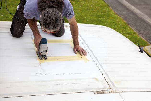 Umbau eines Camper Jumper Van zum Selbermachen. Neues Fenster draußen Schneiden mit einer elektrischen Stichsäge. Vorbereitung für die Installation eines Dachfensters DIY Camper Jumper van conversion. new window outside. cutting with an electric jigsaw. preparation for installing a top window Copyright: imageBROKER Zoonar ibxiqx16143514.jpg ,model released, Symbolfoto ,property released