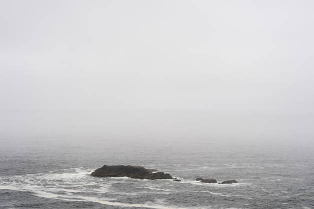 Kuestenlandschaft mit kleinem Felsen im Nebel auf Chiloe (Chile, Patagonien): graues Meer mit niedrigen Wellen; dunkle Felsen kleine Insel im Dunst. Chiloe, 15.12.2025. Chiloe Chile Copyright: xHaukexPfluegerx