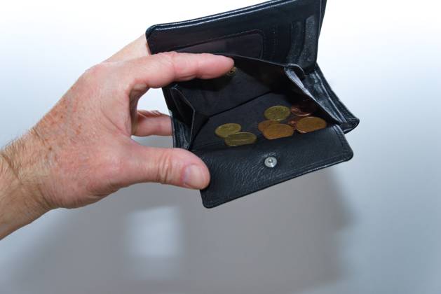 Hand hält beinahe leere Geldbörse auf - Symbolbild für Geldmangel