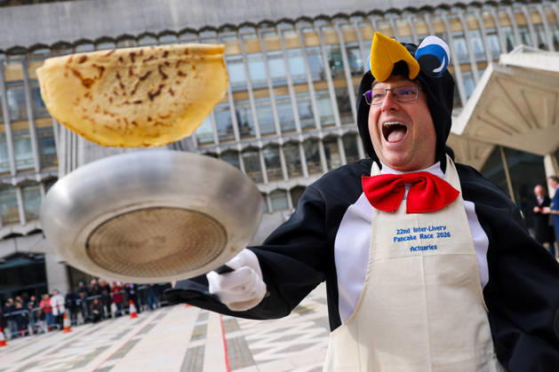February 17, 2026, London, London, UK: London, UK. A participant in fancy dress flips a pancake during the Inter-Livery Pancake Race at Guildhall Yard in the City of London on Shrove Tuesday, raising funds for the Lord Mayors Charity. Members of the City Livery Companies take part in the annual event, also known as the Poulters Pancake Race, racing in ceremonial robes and fancy dress. The event has been held annually since 1983. London UK  - ZUMAl94_ 20260217_zaf_l94_039 Copyright: xDinendraxHariax