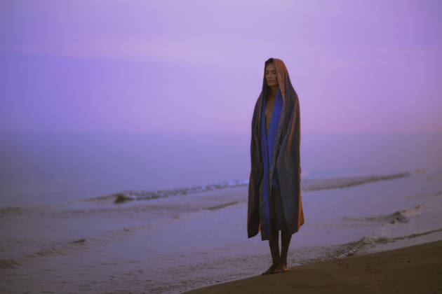 Woman in robe standing on coastline at sunrise in contemplative mood model released, Symbolfoto property released, AZF01134