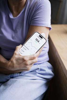 Woman checking blood sugar level with smartphone and glucose monitor model released, Symbolfoto property released, ATSF00315