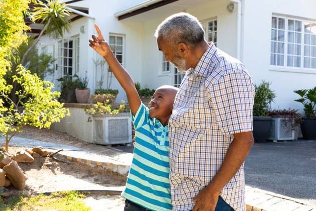 Senior African American man and his grandson spending time together in their garden on a sunny day Senior African American man and his grandson spending time together in their garden on a sunny day, smiling and embracing., model released, , property released, Cape Town, South Africa, 24.01.2020, 1352227.jpg, people,real people,home,domestic life,lifestyle,free time,leisure,relaxing,happy,enjoying,smiling,summer,garden,backyard,sunny,hobby,heathy,nature,heathy lifestyle,active seniors,retirement,interacting,togetherness,closeness,grandfather,grandson,playing,fun,embracing Child,Boy,Male,Black,Senior,Elderly,Man,Mixed-Race Outdoors,Side view,Focus on Foreground,Looking up,Two objects,Day,Half length