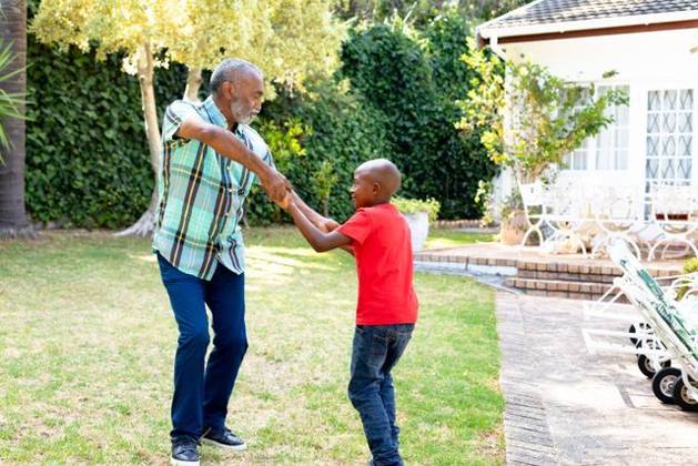 Senior African American man and his grandson spending time together in their garden on a sunny day Senior African American man spending time with his grandson in their garden on a sunny day, teaching him dancing on the lawn., model released, , property released, Cape Town, South Africa, 24.01.2020, 1352259.jpg, people,real people,home,domestic life,lifestyle,free time,leisure,relaxing,happy,enjoying,smiling,summer,garden,backyard,sunny,hobby,heathy,nature,heathy lifestyle,active seniors,retirement,interacting,togetherness,closeness,grandfather,grandson,teaching,learning,dancing,playing,fun Child,Boy,Male,Black,Senior,Elderly,Man,Mixed-Race Outdoors,Side view,Focus on Foreground,Looking Away,Two objects,Day,Full length