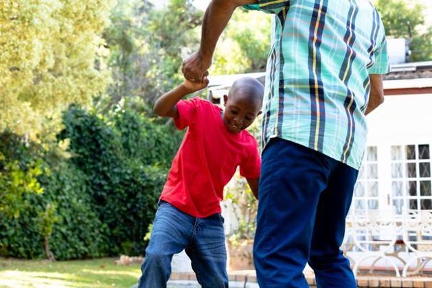 Senior African American man and his grandson spending time together in their garden on a sunny day Senior African American man spending time with his grandson in their garden on a sunny day, teaching him dancing on the lawn., model released, , property released, Cape Town, South Africa, 24.01.2020, 1352261.jpg, people,real people,home,domestic life,lifestyle,free time,leisure,relaxing,happy,enjoying,smiling,summer,garden,backyard,sunny,hobby,heathy,nature,heathy lifestyle,active seniors,retirement,interacting,togetherness,closeness,grandfather,grandson,teaching,learning,dancing,playing,fun Child,Boy,Male,Black,Senior,Elderly,Man,Mixed-Race Outdoors,Side view,Focus on Foreground,Looking Away,Two objects,Day,Three Quarter Length