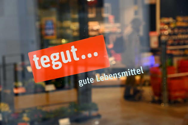 Der Schweizer Konzern Migros zieht sich aus Deutschland zurueck und verkauft die Supermarktkette Tegut. Rund 200 der etwa 340 Filialen will Edeka uebernehmen. Tegut ist ein deutsches Handelsunternehmen und Vollsortimenter im Lebensmitteleinzelhandel mit Hauptsitz in Fulda. Tegut betreibt ueber 300 Filialen mit rund 8400 Mitarbeitern in Hessen, Bayern, Niedersachsen, Rheinland-Pfalz, Thueringen und Baden-Wuerttemberg. Supermarkt,Filiale,Lebensmittel,Eingang, Firmenlogo,