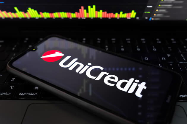 UniCredit Sees Up To â‚¬500 Million In AI Cost Cuts In Next Years The UniCredit logo appears on a smartphone screen, and a stock exchange curve chart displays as the background on a laptop computer screen in this photo illustration in Athens, Greece, on March 18, 2026. UniCredit SpA Chief Executive Officer Andrea Orcel states the bank is quantifying the impact of artificial intelligence at about EUR400 million to EUR500 million ($576 million) in net cost reductions over roughly five years, driven by efficiency gains across core processes such as lending, compliance, and client onboarding. Athens Greece  Copyright: xNikolasxKokovlisx originalFilename: kokovlis-notitle260318_npYRE.jpg