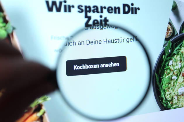 Auf einem Laptop wurde die Website der HelloFresh SE aufgerufen. Eine Lupe zeigt auf den Button, mit dem Kunden zu den Kochboxen geraten. Symbolbild Symbolfoto. Schnelsen Hamburg