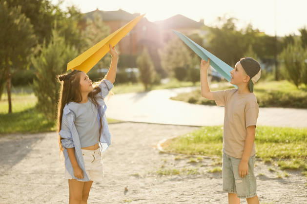 Kids playing with paper planes at a park on a sunny summer day model released, Symbolfoto, ONAF01189