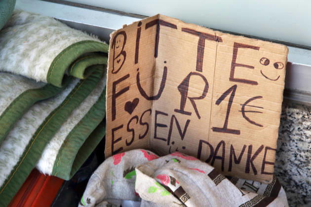 OBDACHLOSIGKEIT - BITTE FÜR 1 EURO ESSEN DANKE - Lebenswelt von Menschen ohne festen Wohnsitz - 06.03.2026, Fulda, Deutschland, GER, DEU - Div. Habseligkeiten (Decken) eines offenbar wohnungslosen Menschen in der kalten Jahreszeit am Straßenrand. Er bittet vorbeikommende Mitbürger um eine Spende für Nahrung. Immer mehr Menschen leben in Deutschland ohne festen Wohnsitz auf der Straße. Verstärkt wird das Problem der Obdachlosigkeit noch durch Menschen aus anderen Ländern der Welt, die ohne feste Bleibe in Deutschland leben und versuchen zu überleben.