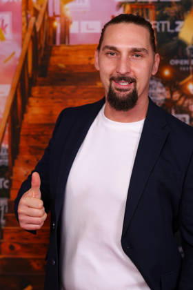 Sandy Fähse steht auf dem roten Teppich vor der Kino-Preview von Kampf der RealityAllstars.