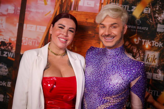 Kate Merlan und Sam Dylan stehen auf dem roten Teppich vor der Kino-Preview von Kampf der RealityAllstars.