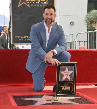 American actor, director and writer Noah Wyle kneels next to his star during an unveiling ceremony honoring him with the 2,840th star on the Hollywood Walk of Fame in Los Angeles on Thursday, April 9, 2026. LAP20260409909 JIMxRUYMEN